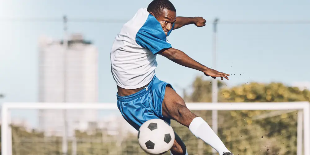 footballer kicks the ball in the air