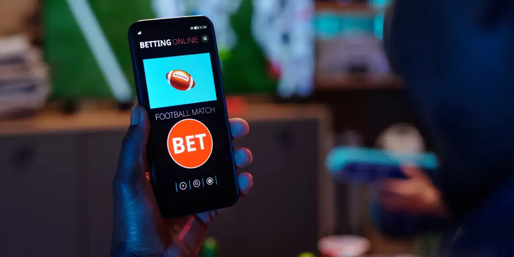 man wagering a bet on mobile phone