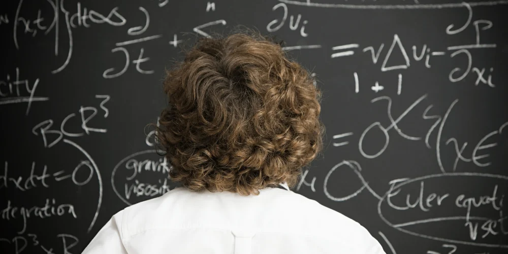 man solving a tough math problem on the blackboard